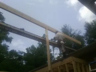 Carpenter setting a ridge beam over a new addition frame — Ice Dam Removal by Roofing Brothers in Rio Medina