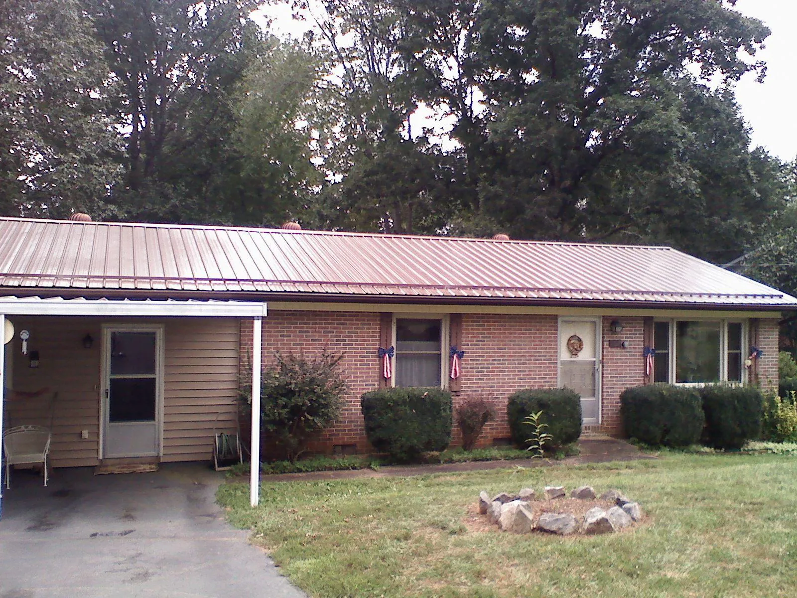 Bronze metal roof and carport on a brick ranch home — Roof Repair work by our crew in Rio Medina